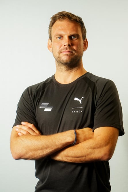 A man posing with his arms crossed across his torso.