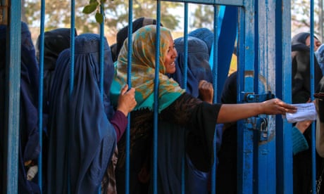 Displaced women queue to receive food aid in Kabul