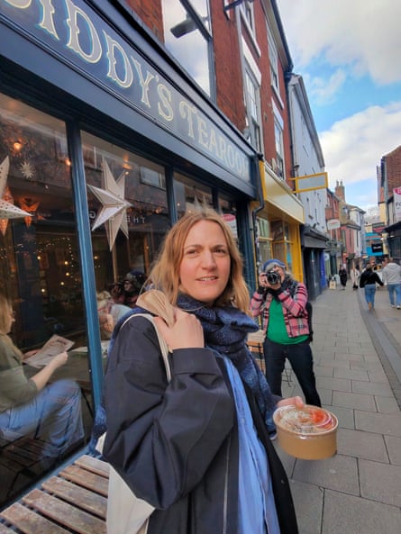 A woman in the street holding a takeaway food container
