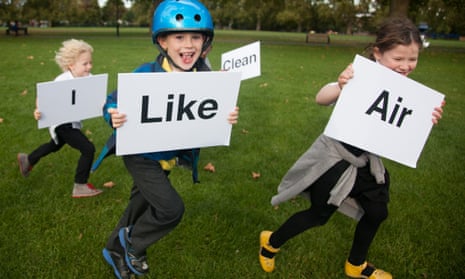 children run outside with signs that read "I like clean air"