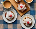 Benjamina Ebuehi's iced Belgian buns with cherries on plates, beside cups of tea