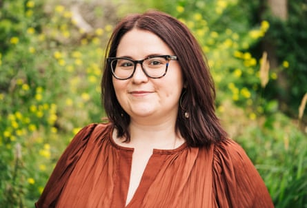 A women wearing glasses smiles at the camera.