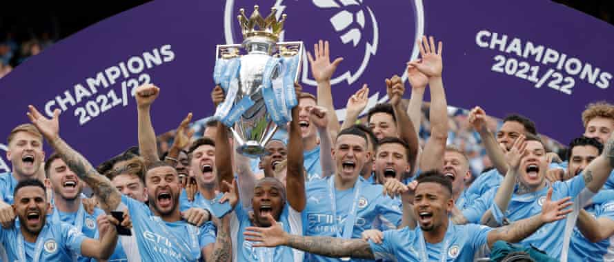 Fernandinho lifts the Premier League trophy as his Manchester City team-mates celebrate their triumph.