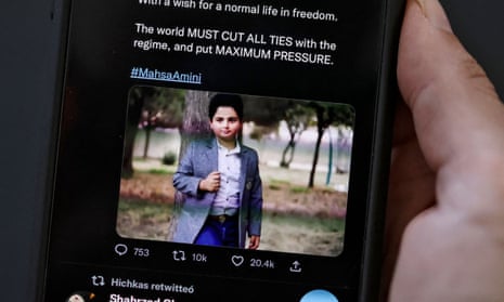 A woman looks at a tweet reportedly showing Kian Pirfalak, the Iranian boy killed in a shooting this week in the western Iranian town of Izeh.
