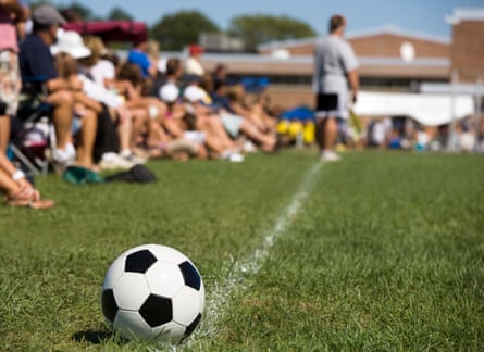 Parents and spectators watch a football match