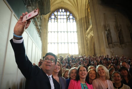 Andy Burnham takes a selfie with a phone in front of the crowd of MPs