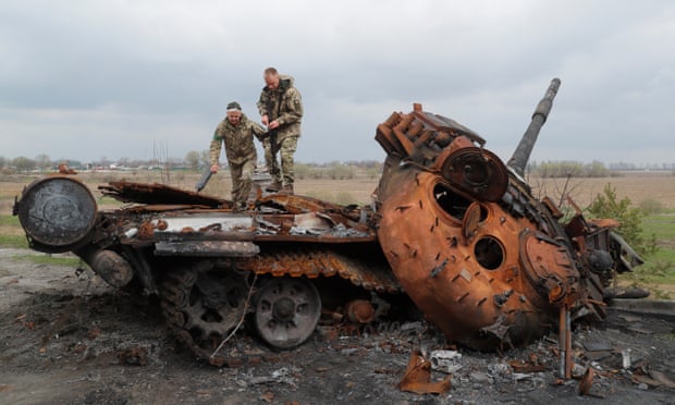 Ukrainian soldiers inspect a destroyed Russian tank on the outskirts of Kyiv, 16 April.