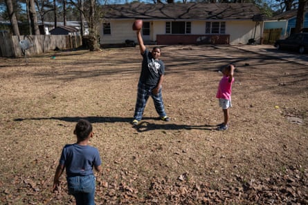 Three kids playing football outside