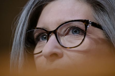 a woman wearing glasses looks ahead