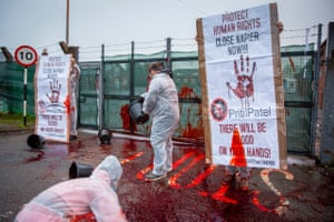Folkestone, UK: Activists throw buckets of fake blood through the gates of Napier barracks, aiming to send a message to Priti Patel and the Home Office about concerns over the living conditions of asylum seekers at the facility