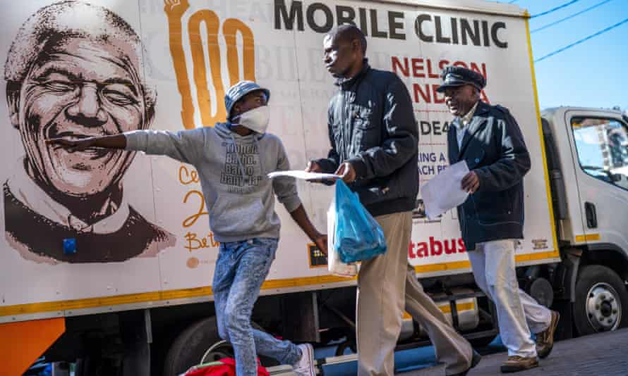 A volunteer in Johannesburg directs two men towards a medical tent where they will be tested for Covid as well as HIV and TB.