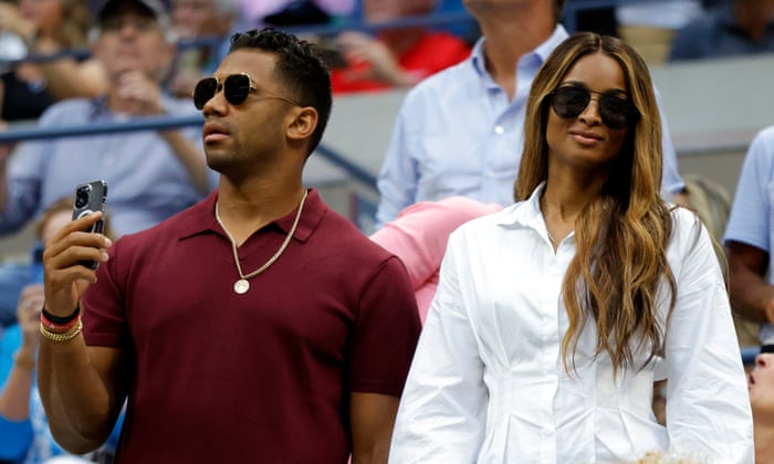 Russell Wilson and Ciara take in the match.