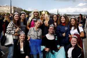 Students wearing crowns and tiaras pose as they wait for the arrival of Britain’s King Charles and Queen Camilla on Place de la Bourse square in Bordeaux
