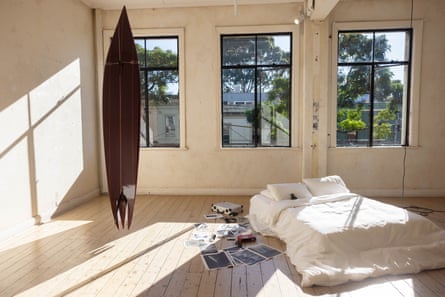 An apartment with a mattress on the floor beside a strange surfboard that is long and has a spiky end