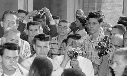 A close up of the North Little Rock High School photo. Jerry Jones is in a horizontal striped shirt, to the right of the raised camera