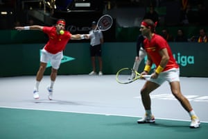 Spain’s Feliciano Lopez plays a forehand return as Rafael Nadal looks on.
