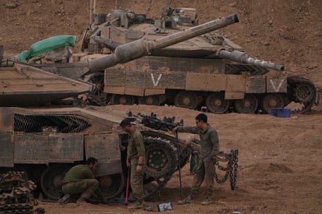 Israeli soldiers work on a tank near the Israeli-Gaza border, as seen from southern Israel, on Thursday.