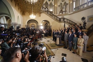 Paetongtarn Shinawatra stands at a lectern in front of a crowd of photographers