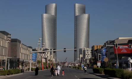 A family walk down the car-free as the four towers at Al Sa’ad Plaza cn be seen from Lusail Boulevard.