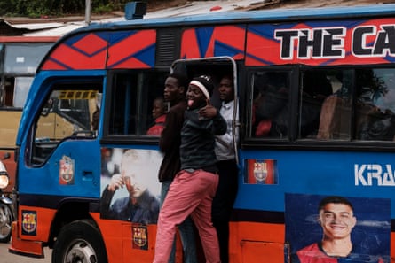 A matatu conductor gestures to roadside passengers in Kibera
