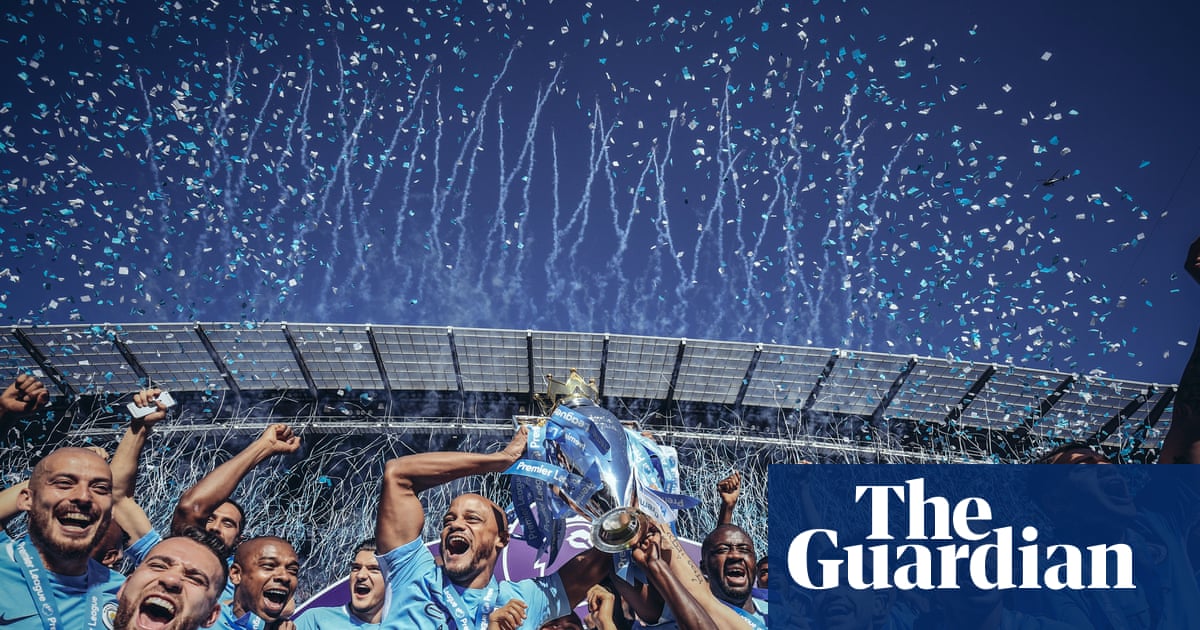 Fachada del Etihad Stadium, estadio del Manchester City, con el escudo del club visible en un día despejado.