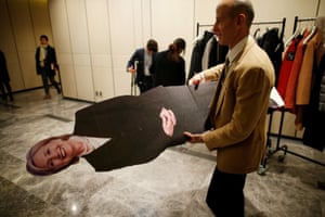 A man carries away a cut-out of Hillary Clinton