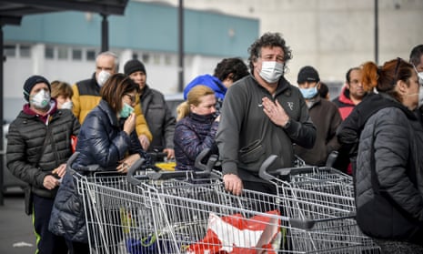 People wear masks outside a supermarket in Casalpusterlengo, Italy