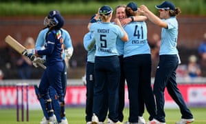Kate Cross celebrates the wicket of Sneh Rana with teammates.