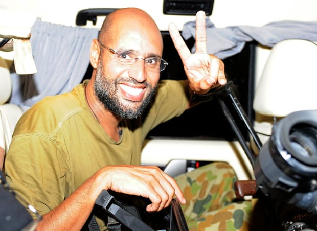 Saif al-Islam Gaddafi, the son of Libyan leader Muammar Gaddafi, gestures as he talks to reporters in Tripoli in August 2011.