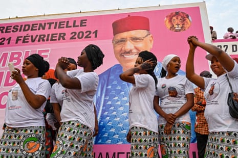 Supporters dance next to a poster during the coalition campaign rally of Mohamed Bazoum, who won a landslide victory on 23 February.