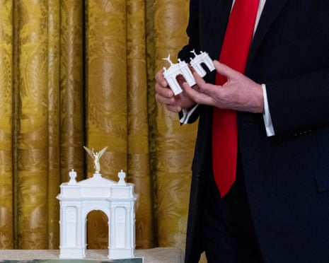 Donald Trump holds up a model for his proposed “arc” at a dinner for donors to his White House ballroom on 15 October.