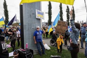 People hold placards and Ukrainian flags