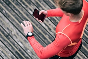 Running man checking sport performance on his mobile phone and smartwatch app