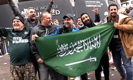 Jubilant Newcastle United fans hold a Saudi flag outside St James' Park. 