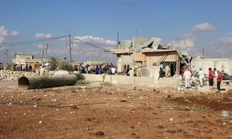 People gather outside damaged and destroyed buildings in the Syrian town of Idlib following Russian airstrikes