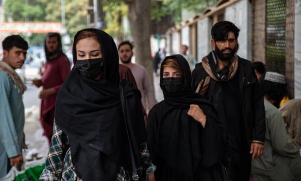 Kabil'de bir sokakta yürüyen kadınlar yüzlerini kapatıyor