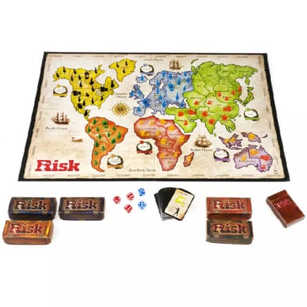 A Risk board game set with a world map, pieces, dice, cards and boxes displayed together