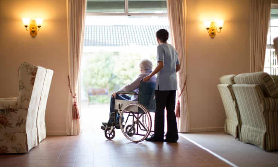 Care home Nnrse pushing patient in wheelchair