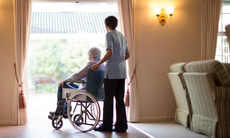 A nurse pushing patient in wheelchair in a care home.