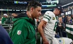 Aaron Rodgers is helped off the field after suffering a suspected achilles injury on his Jets debut