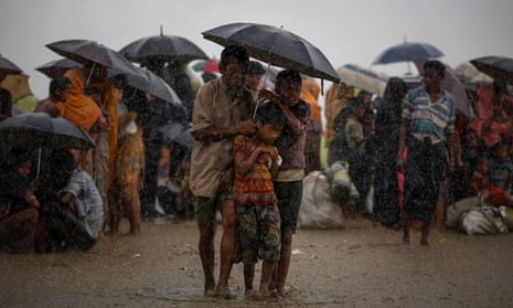 Rohingya refugees shelter from torrential rain after crossing the border into Bangladesh