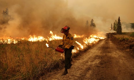 A firefighter conducts a controlled ignition on a wildfire in Alberta