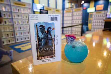 blue drink in fishbowl-shaped glass next to Avatar video case