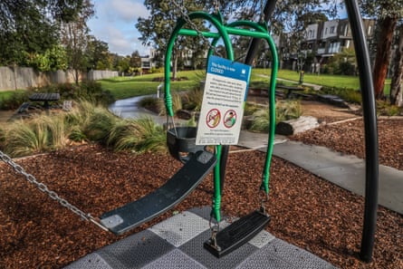 Two swings sit tied together with a sign advising the closure of a playground in the local government area of Monash in Melbourne on Tuesday.