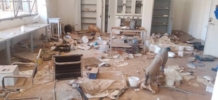 An office with wrecked furniture and debris scattered across the ground