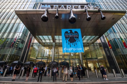 Greenpeace activists put up a banner showing the Barclays logo dripping with oil at its office in London.