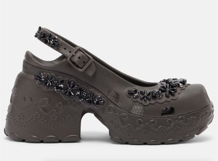 A side-on view of a platform clog embellished with black floral jewels