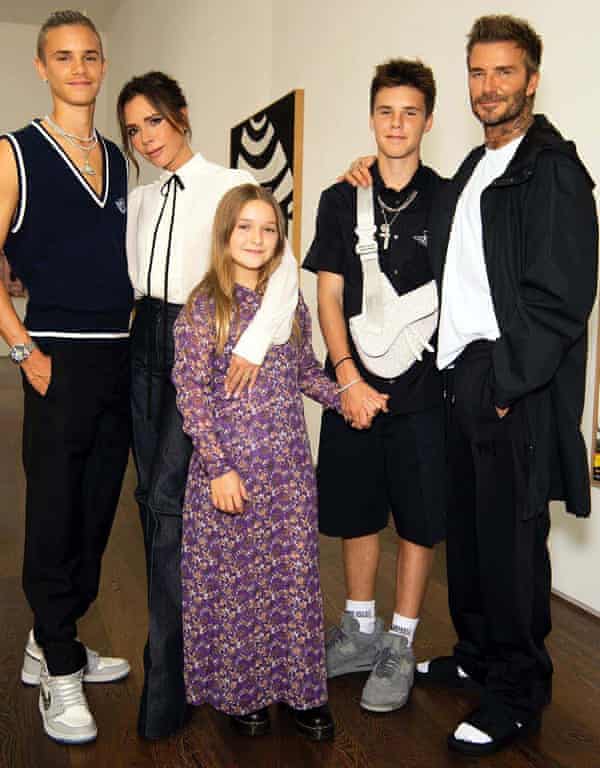 David Beckham, in his sliders and socks, with Victoria and their children Romeo (far left), Cruz and Harper Seven.