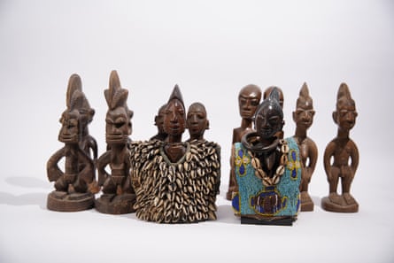 A collection of carved figures, some decorated with small shells