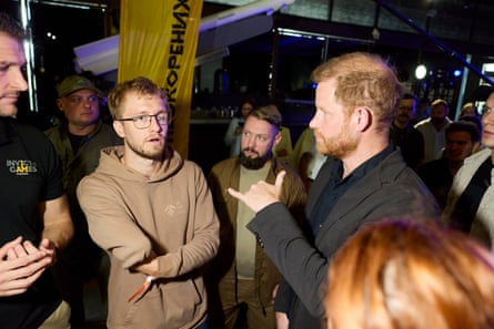 Harry speaks with veterans at the event.